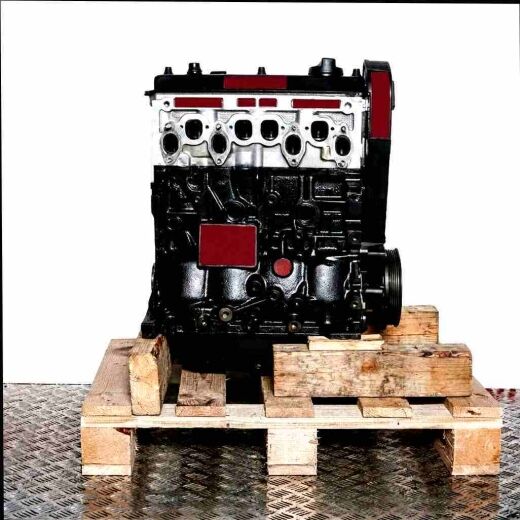Black 1Z engine on a wooden pallet against a white background. The engine with a silver cylinder head is shown vertically.