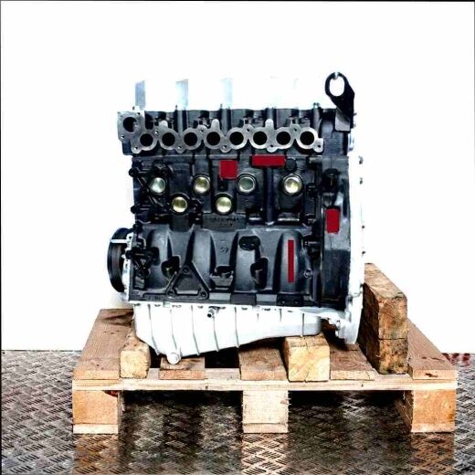 Black AGK engine on a wooden pallet against a white background. Side view of the engine with silver cylinder head and oil pan.