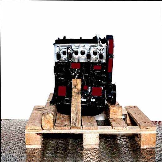 AHU engine on a wooden pallet against a white background. The black and grey engine is vertically oriented, with some parts visible in transparent packaging.