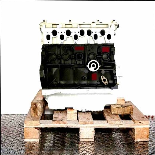AJT engine on a wooden pallet against a white background. The partially assembled engine features a black block and silver components.