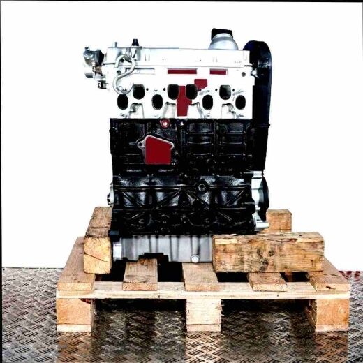 AQM diesel engine on a wooden pallet against a white background. Side view of the engine with a silver cylinder head and black engine block. Includes attachments in a plastic bag.