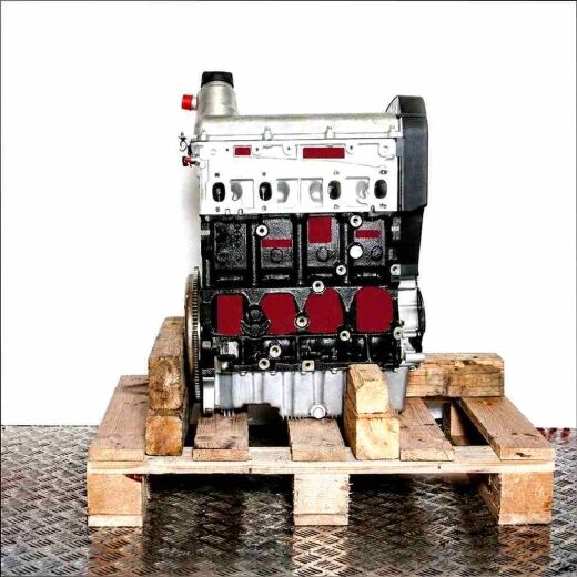 ATM engine on a wooden pallet against a white background. Black and silver engine, viewed from the front.