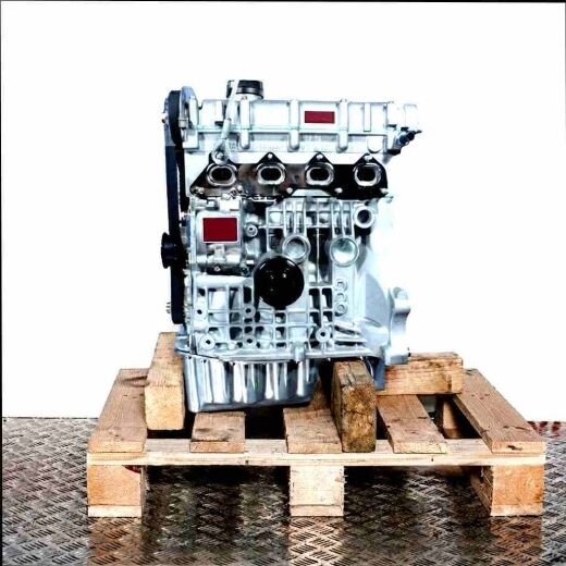 Side view of a silver engine, code AUA, on a wooden pallet. The engine, showing parts like the timing belt, is set against a white background.