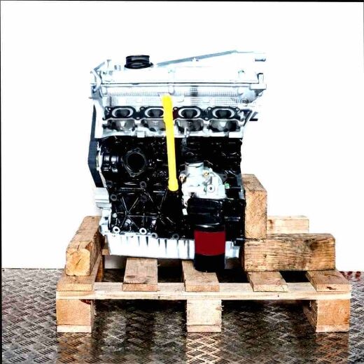 AUQ engine on a wooden pallet against a white background. The silver cylinder head and black engine block are visible, along with the yellow oil dipstick. Oil filter on the bottom right.