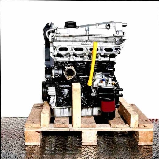 AWC engine on a wooden pallet against a white background. The black and silver engine with a yellow oil dipstick is vertically oriented.