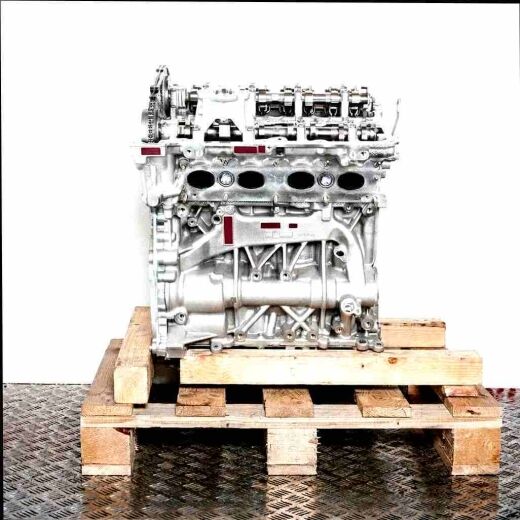 Silver engine B46 B20 B on a wooden pallet against a white background. Side view of the engine, perfect for technical applications.