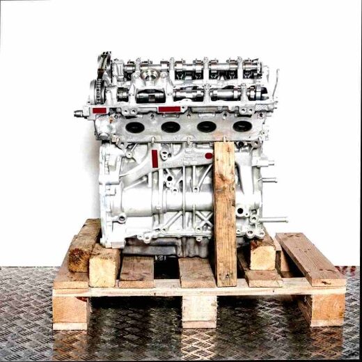 Side view of a silver B48 B20 B engine on a wooden pallet against a white background. The engine, with visible components, is shown in detail.