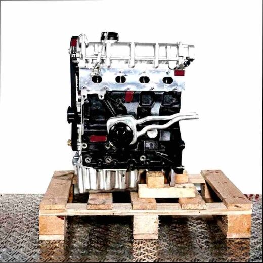 BAD engine on wooden pallet against white background. Black engine block, silver cylinder head. Side view.