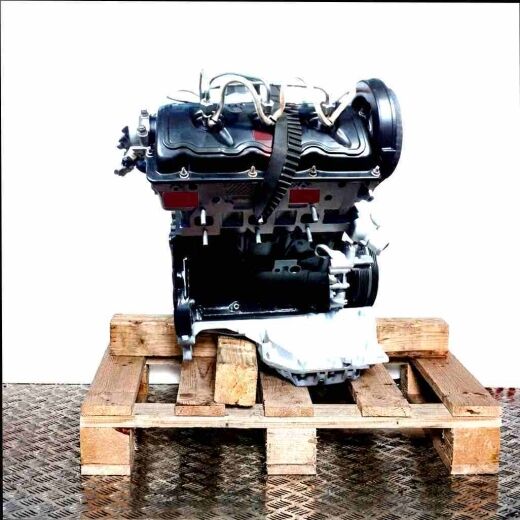 BDH inline engine in black and silver on a wooden pallet against a white background. Side view of the engine, vertically oriented.