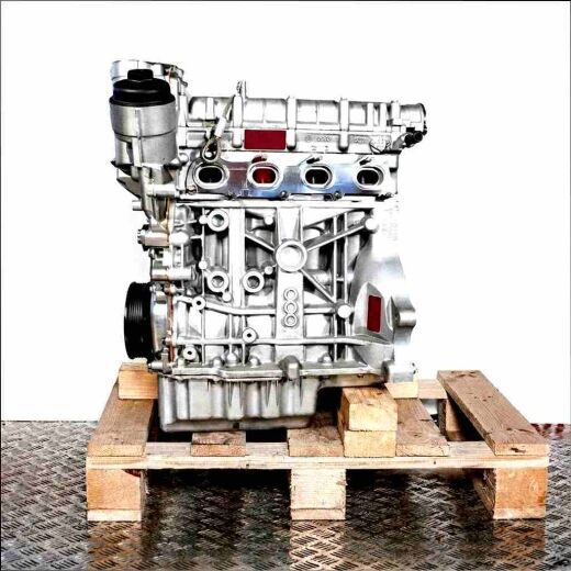 BTS engine on a wooden pallet against a white background. Detailed side view of the silver engine, vertically oriented.