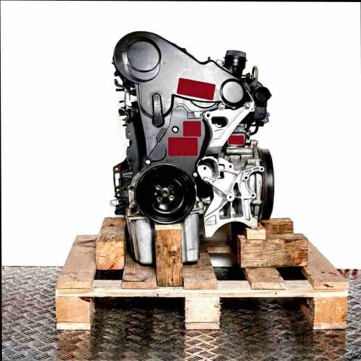 Side view of the CSLC engine on a wooden pallet against a white background. The engine, featuring a black cover and silver oil pan, is vertically oriented.