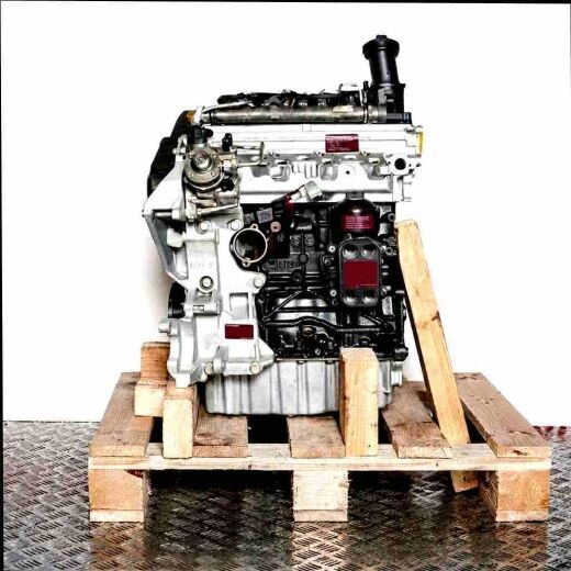 Side view of the CXGA engine on a wooden pallet against a white background. The engine is primarily black and silver.