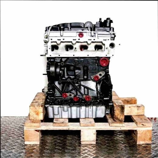 Side view of a DGTE engine on a wooden pallet against a white background. The engine block is black, the cylinder head light gray, with yellow caps.