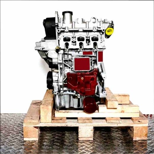 Side view of the DKLA engine on a wooden pallet against a white background. The silver engine with black components is vertically oriented.
