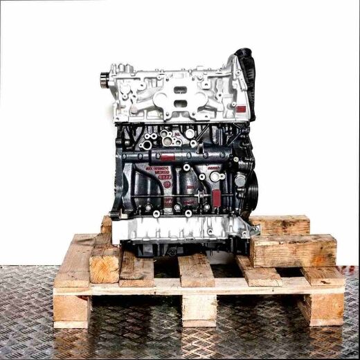 Side view of a DKZA engine on a wooden pallet against a white background. The dark gray engine block is contrasted by the silver-gray components.