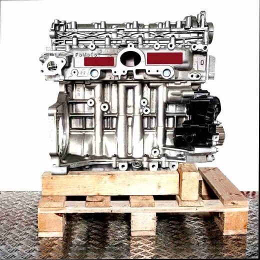 DV5RC engine on a wooden pallet against a white background. Detailed view of the silver engine with black components.