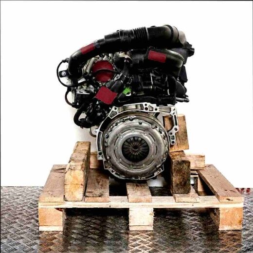 Side view of an HNP (EB2ADT) engine on a wooden pallet against a white background. The engine displays black hoses and metallic components, including a circular coupling.