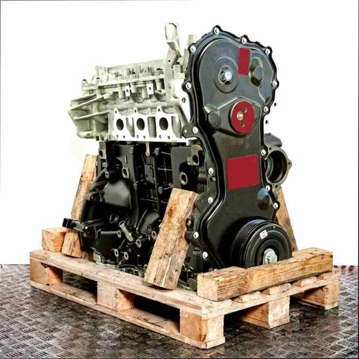 Side view of engine M9T 898 on a wooden pallet against a white background. The silver and black engine is captured at a slight angle.