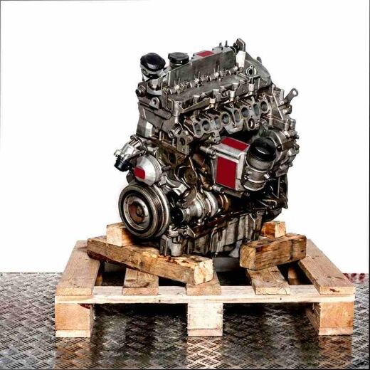 N47 C16 A engine on a wooden pallet against a white background. Side view of the engine.