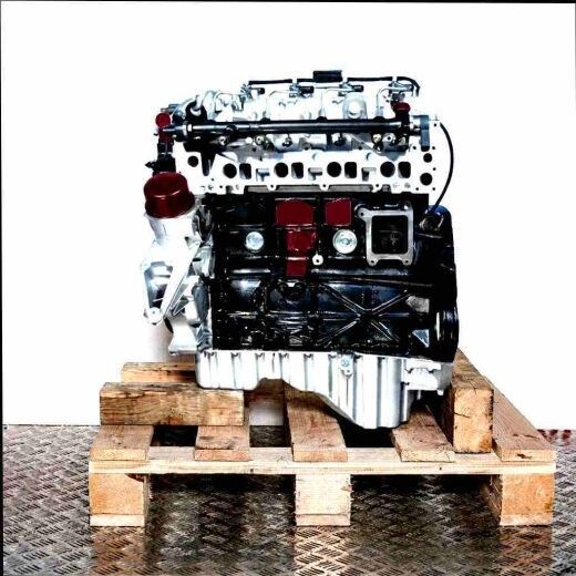 Side view of engine OM 611.962 on a wooden pallet against a white background. Visible components include the cylinder head, fuel injection lines, and crankcase.