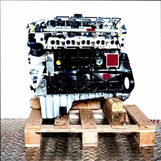 Side view of the OM 612.963 engine on a wooden pallet against a white background. The engine features black and silver components.