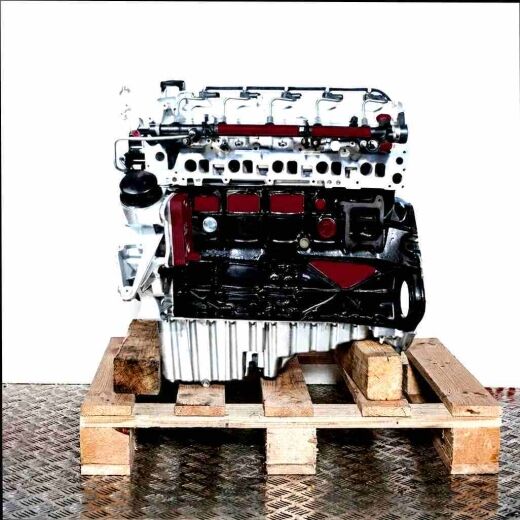 Side view of an OM 612.981 engine on a wooden pallet against a white background. The engine features silver and black parts with visible hoses and connections.