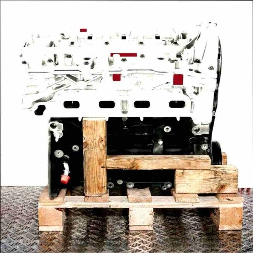 OM 622.851 engine on a wooden pallet against a white background. The silver upper and black lower parts of the engine are visible.
