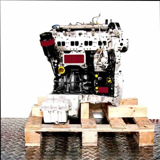 OM 651.957 engine on a wooden pallet against a white background. Side view of the black and silver engine.