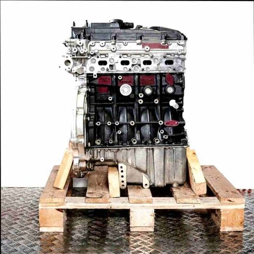 OM 651.958 engine in black and silver on a wooden pallet against a white background. Various connectors and screws are visible.