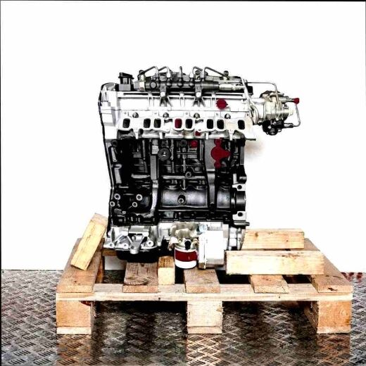 Side view of a black and gray engine (QVFA) with yellow accents, on a wooden pallet against a white background. The engine is vertically oriented.