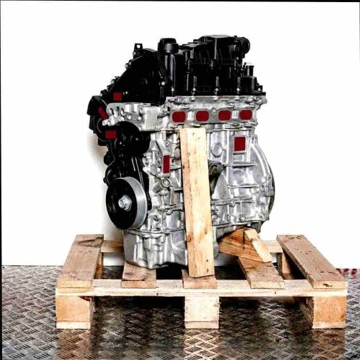 Side view of an XUJG engine on a wooden pallet against a white background. The engine features black covers and silver metal parts.